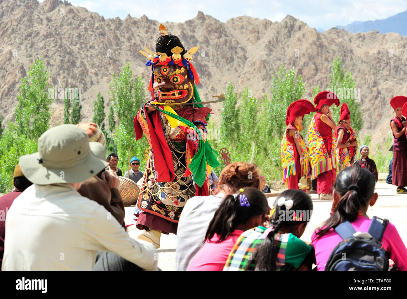 Touristen, die gerade Maskentanz, Kloster Festival, Phyang, Leh, Tal des Indus, Ladakh, Jammu und Kaschmir, Indien Stockfoto