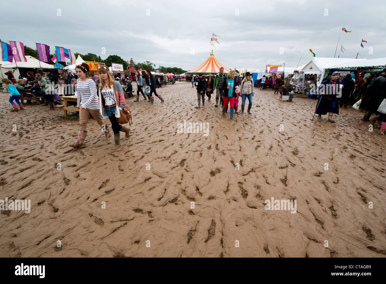Besucher des Larmer Baum Festivals in Dorset trotzen die schlammigen Bedingungen nach Unwetter über Großbritannien fegt Stockfoto