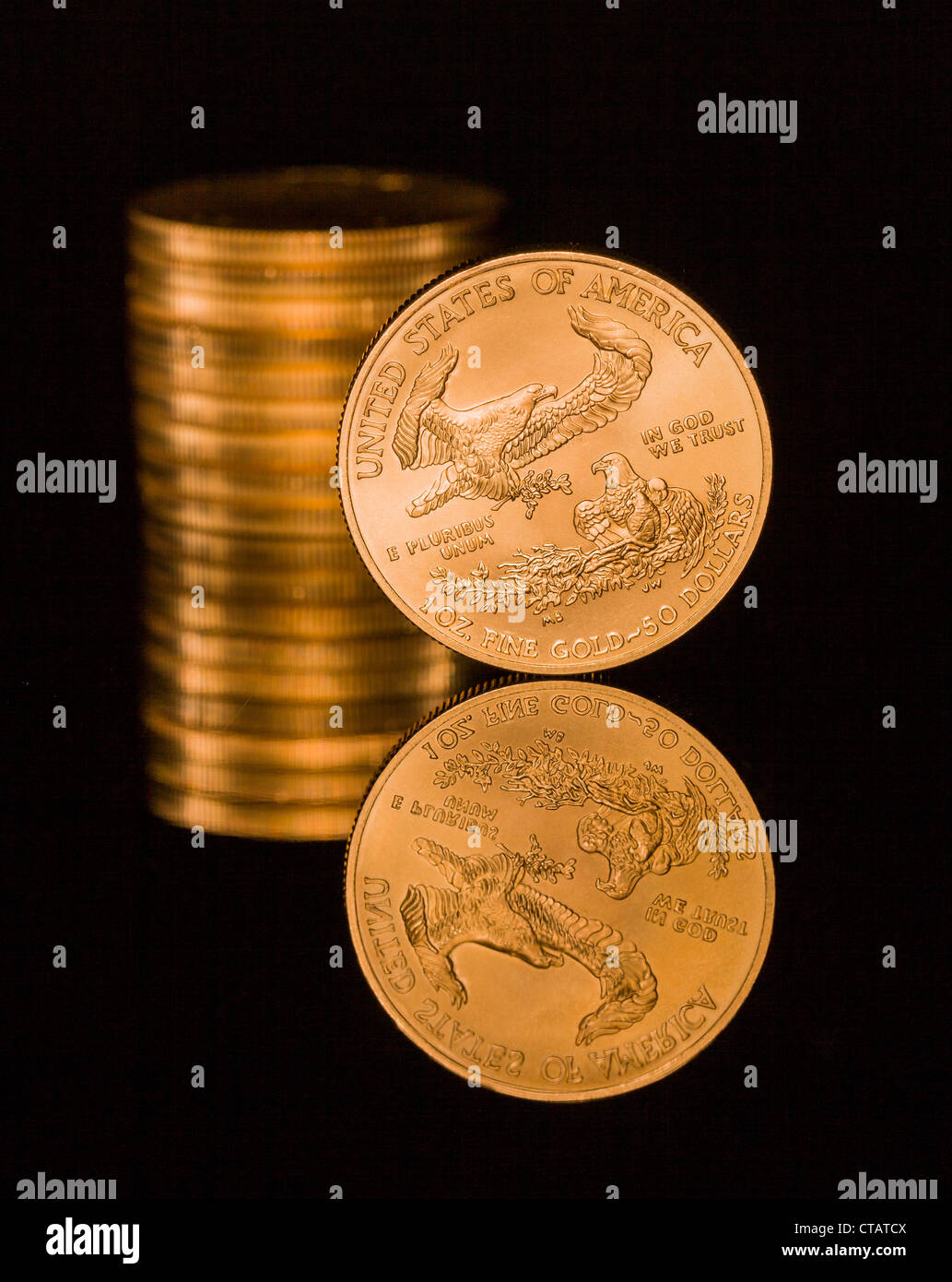 Reflexion der einzelnen Goldmünze und Stack auf schwarze polierte Oberfläche Stockfoto