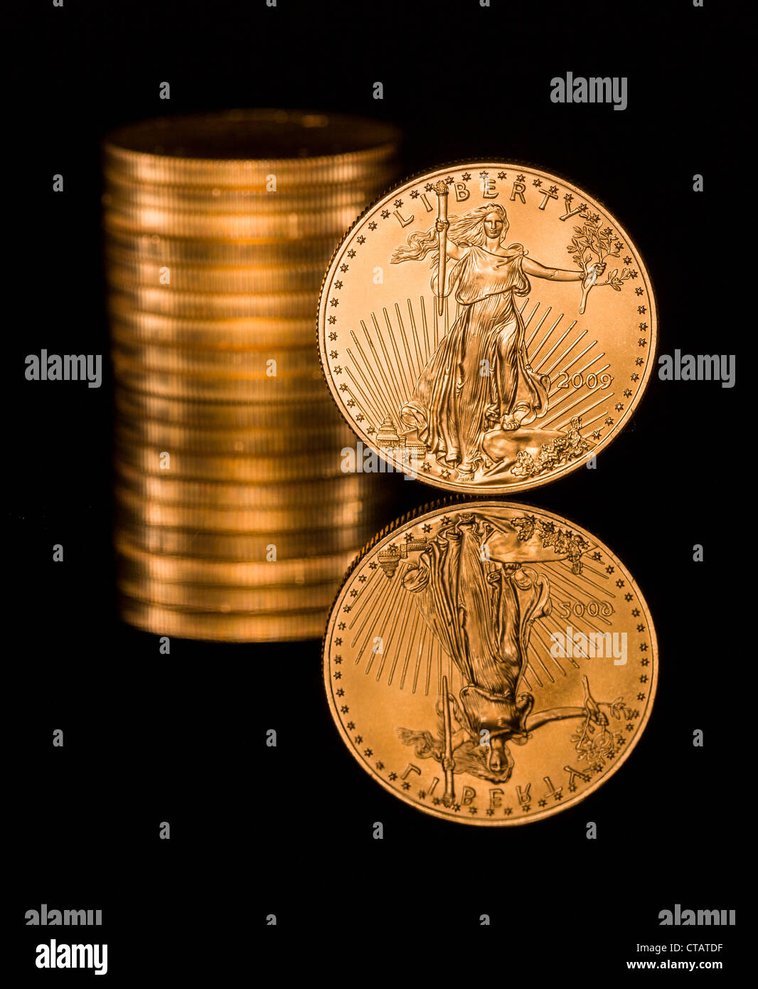 Reflexion der einzelnen Goldmünze und Stack auf schwarze polierte Oberfläche Stockfoto