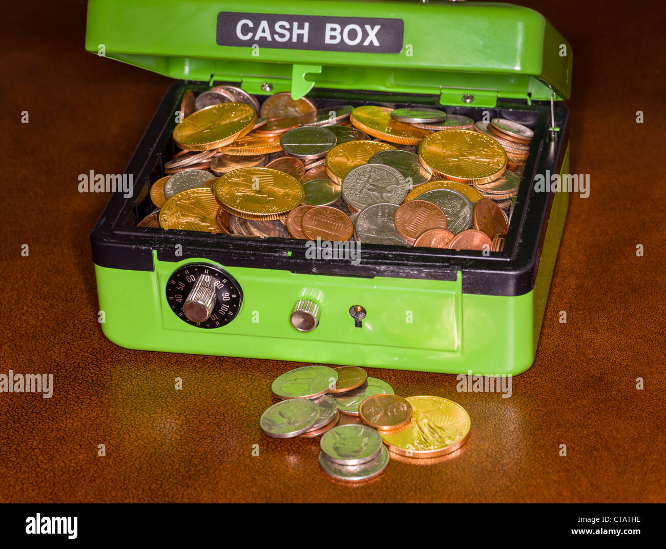 Grüne Geldkassette mit Zahlenschloss für Pfähle wie Gold und Silber-Münzen zeigen offen Stockfoto