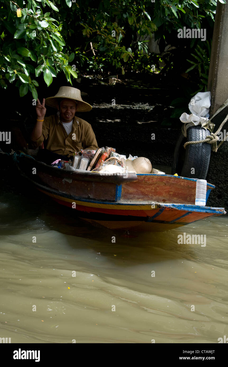 Eine thailändische Hersteller Zuflucht im Schatten vor der Hitze des Tages in ihr Boot in Bangkok, Thailand Stockfoto