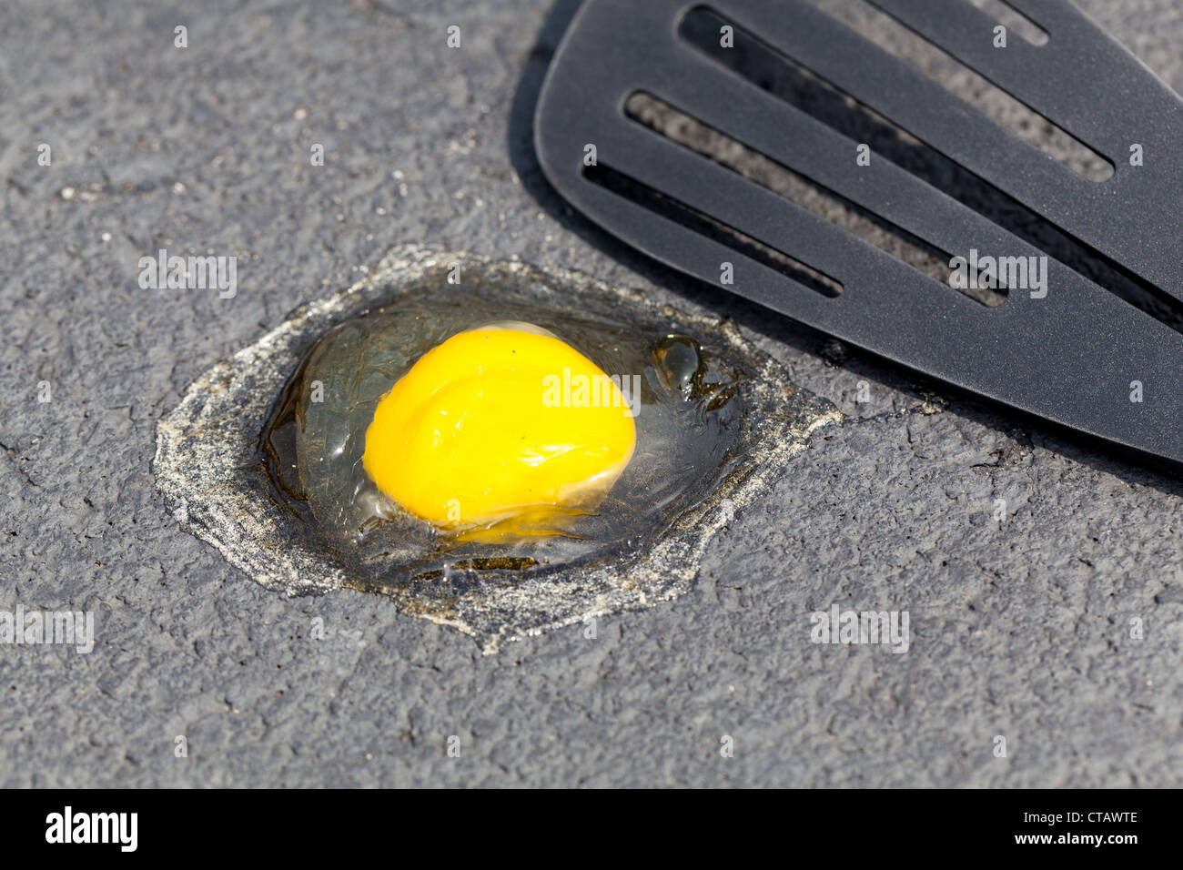 Ei auf heißen Fahrbahn zu sehen, ob es im Sommer Pommes zu brechen Stockfoto