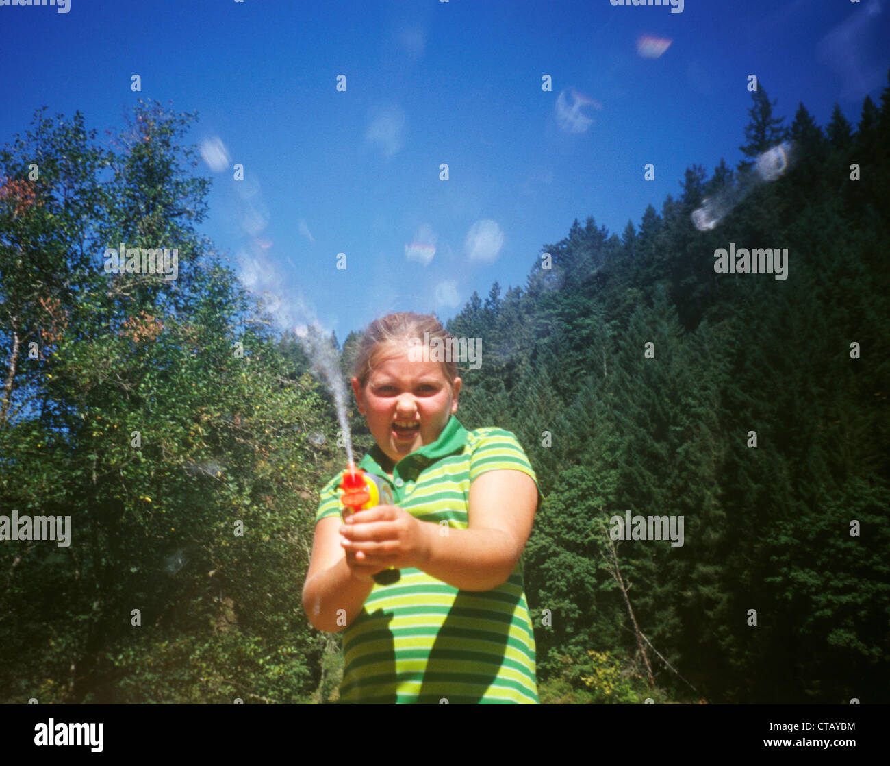 Ein junges Mädchen, die Squirtgun auf die Kamera zu schießen Stockfoto