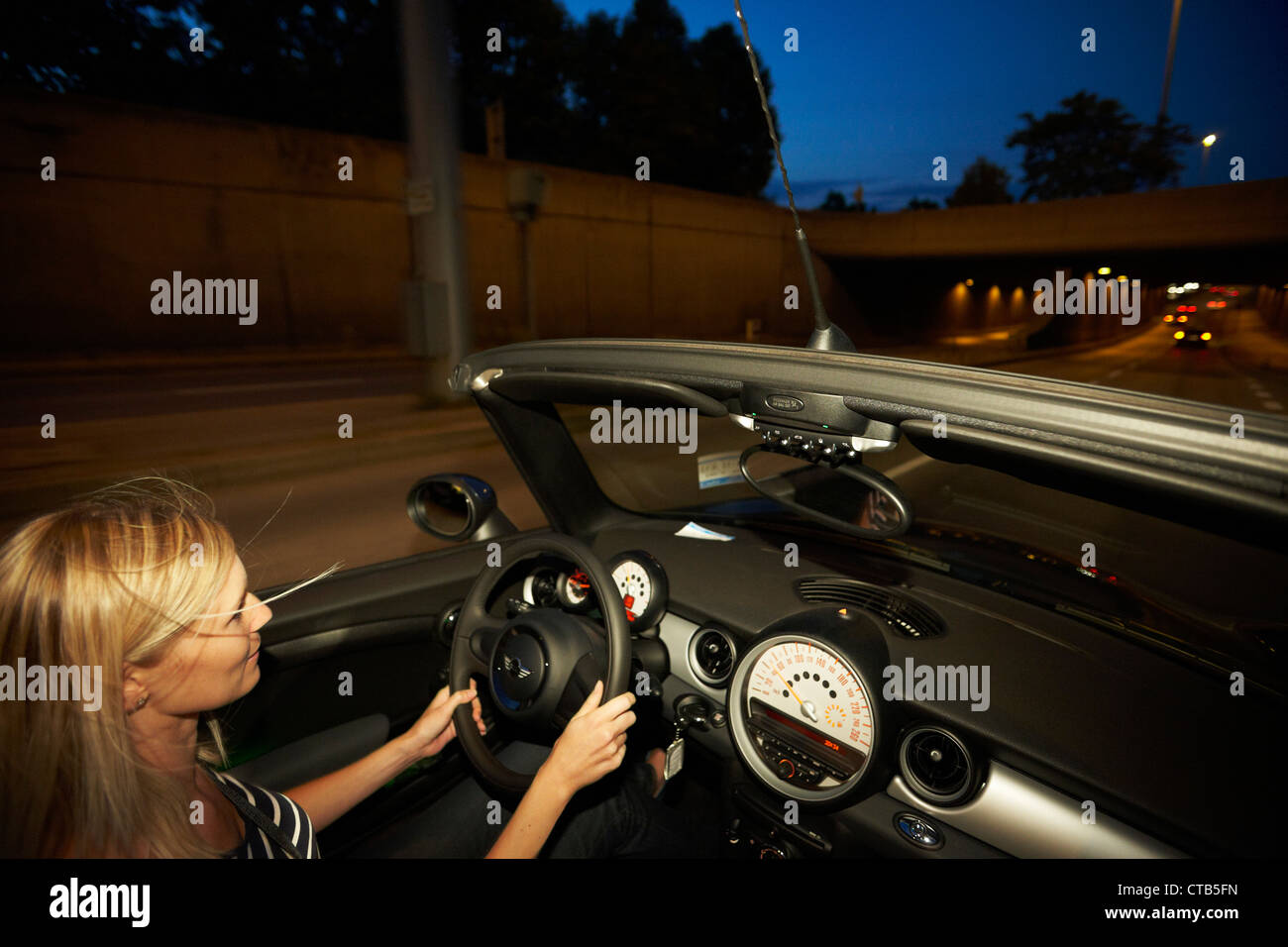 Junge Autofahrerin in einem Cabrio bei Nacht, Stuttgart, Baden-Württemberg, Deutschland Stockfoto