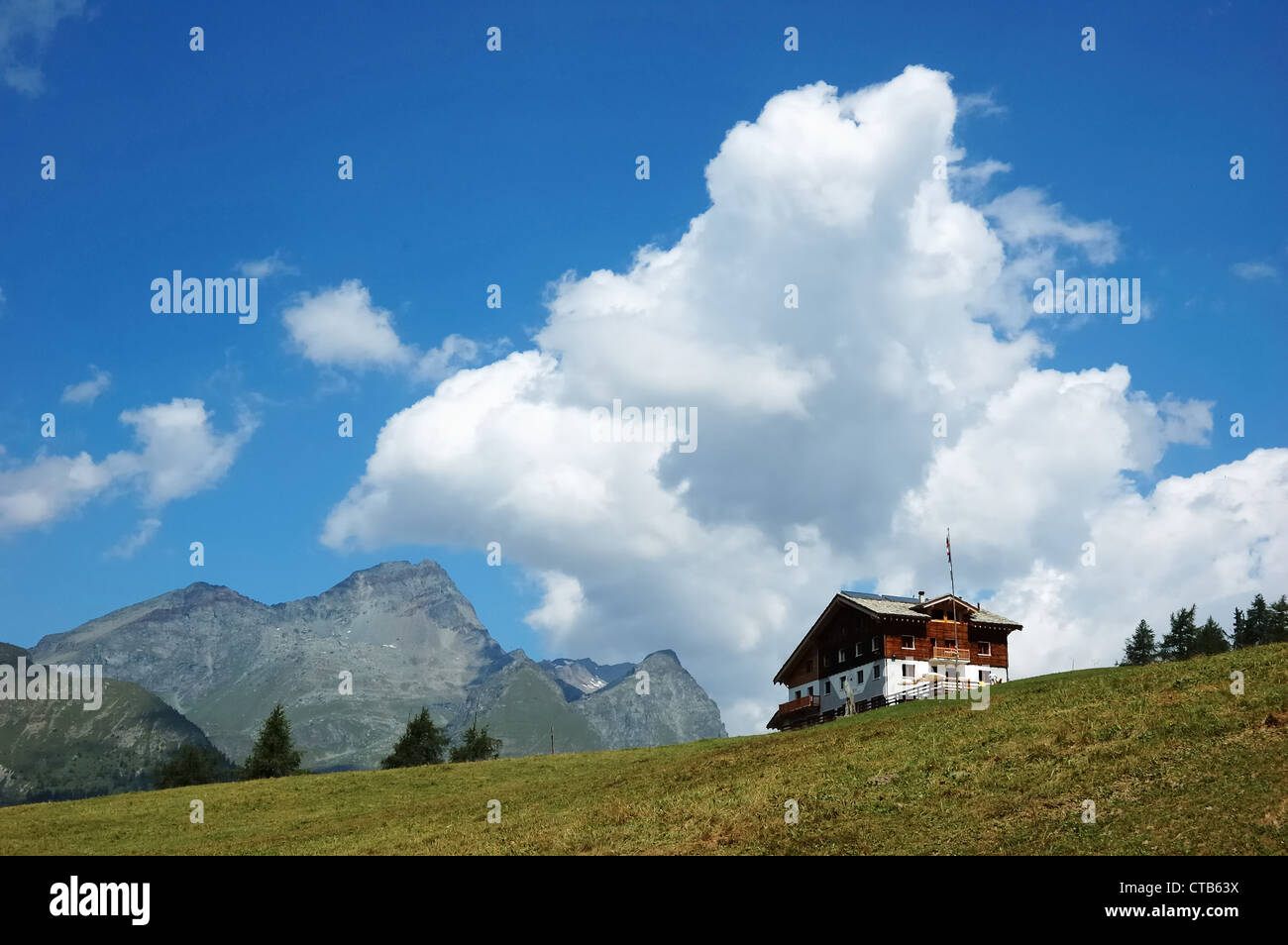 Mountain Lodge in italienischen Alpen; im Hintergrund eine Felsenspitze, bewölkter Himmel; Sommer-Saison. Stockfoto