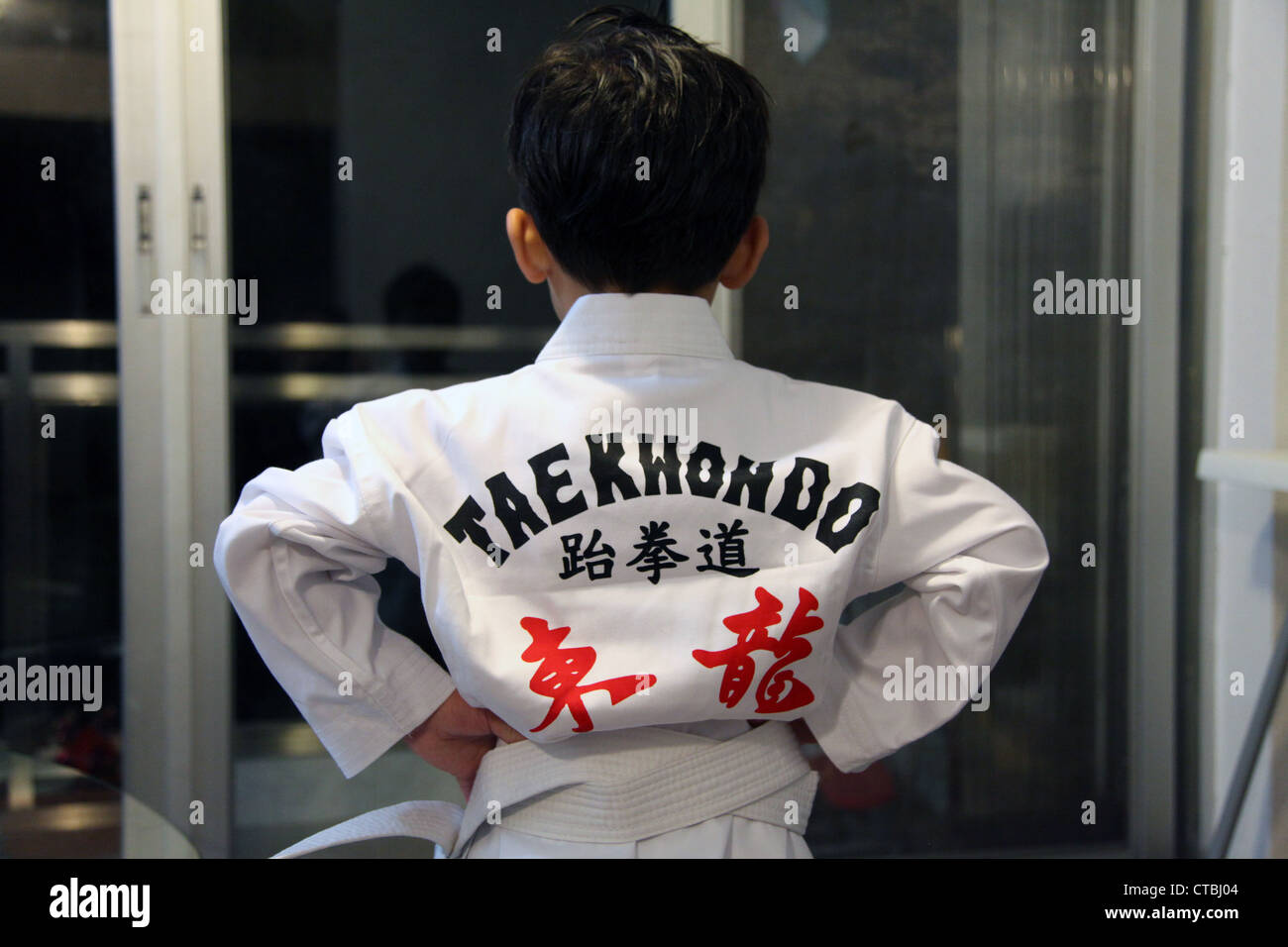 Es ist ein Foto von ein wenig junge-Ansicht von hinten. Er trägt einen Taekwondo-Anzug, eine koreanische Kampfkunst. Stockfoto