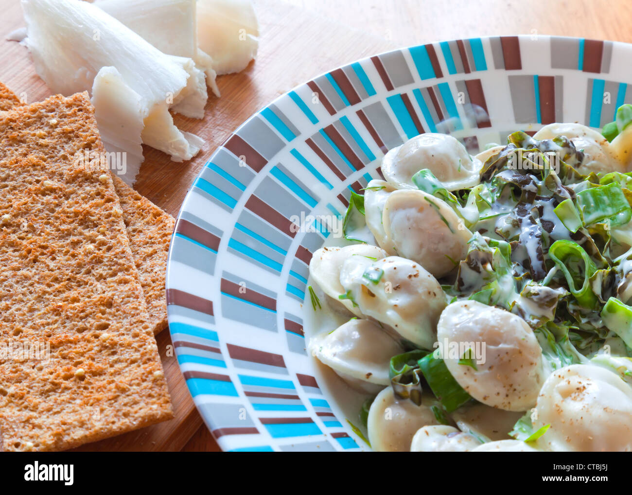 Pelmeni (Fleischklößchen) mit grünen, Knäckebrot und Fett. Modernen täglichen russische Küche Stockfoto