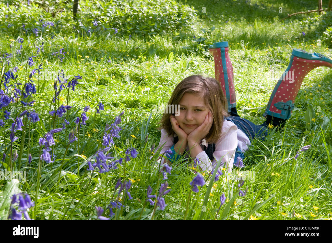 Porträt eines jungen Mädchens in liegend mit dem Kopf in die Hände unter den Glockenblumen Stockfoto