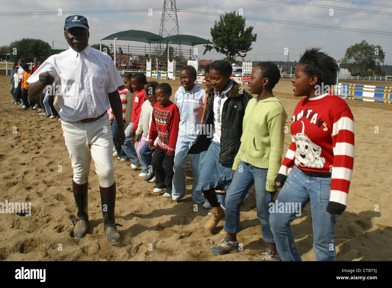 Enos spenden einige Kinder, die Rennen aufgedreht für Soweto Reitschule auf diesem Bild, das sie Gäste singen. PhotoAntony Stockfoto