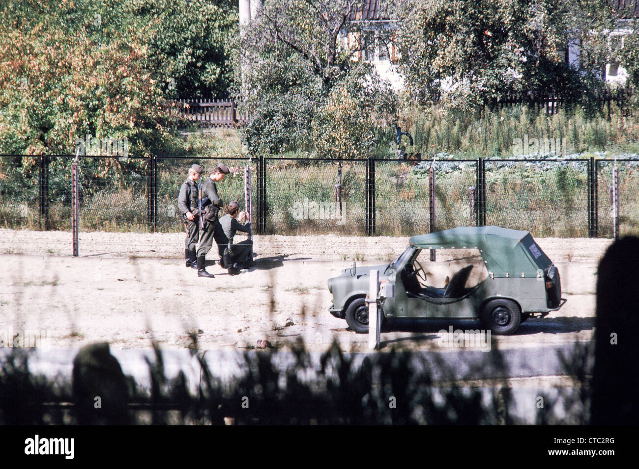 Die Berliner Mauer in Staaken während des Kalten Krieges - ostdeutschen Soldaten inspizieren die Wand im Jahr 1975 Stockfoto