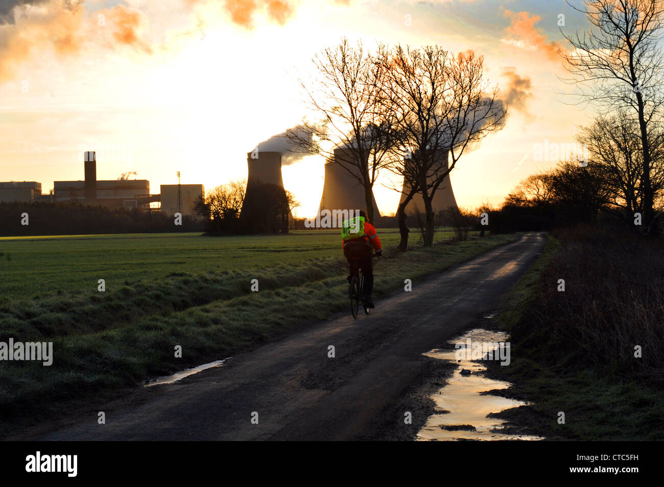 Mann Zyklen seine Art um zu arbeiten an Drax Kohlekraftwerk, North Yorkshire UK Stockfoto