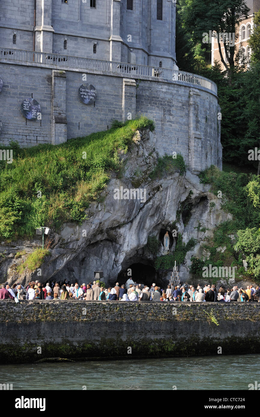 Pilger beten vor der Grotte an der Wallfahrtskirche unserer lieben Frau von Lourdes, Pyrenäen, Frankreich Stockfoto