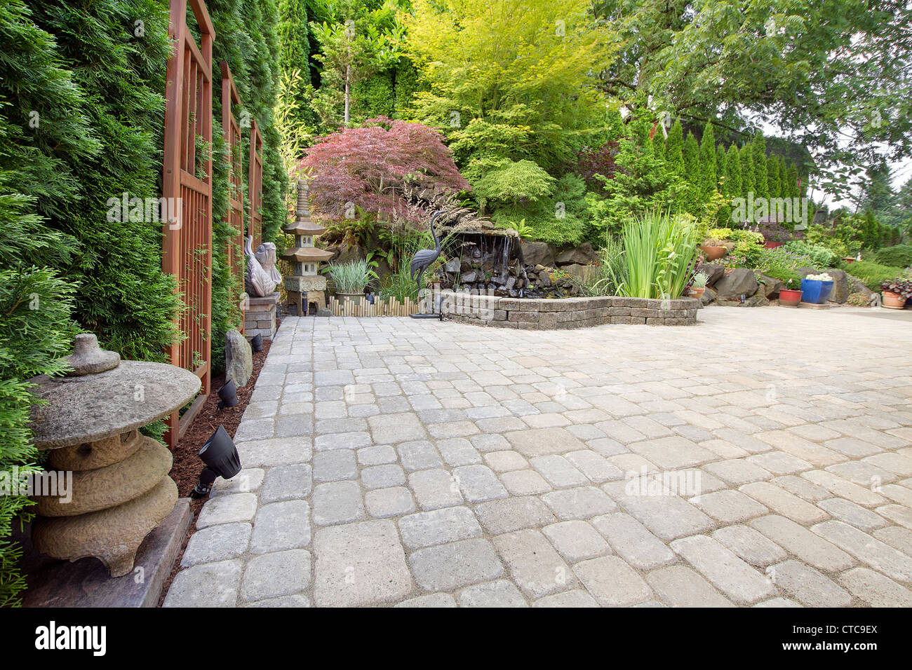 Hinterhof-Garten asiatisch inspirierte Fertiger Terrasse mit Pagode Teich Bronze und Stein Skulpturen Stockfoto