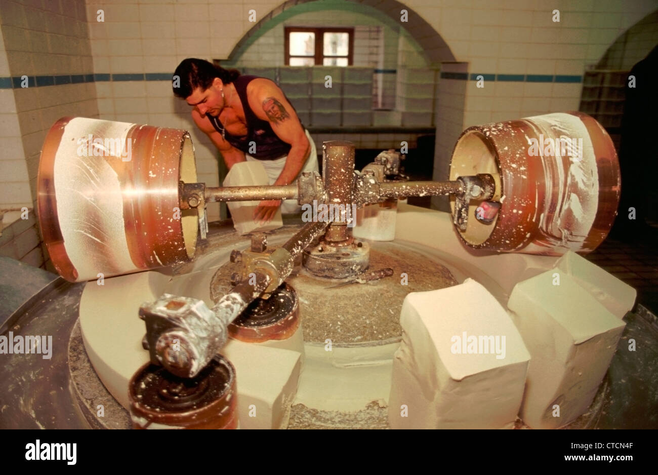 März 2004. Schloss Nymphenburg, München, Deutschland. Ein Arbeiter der Porzellanfabrik hebt schwere Blöcke von nassen Porzellan die rollte vor der Einlagerung und nach vier Monaten verwendet. Stockfoto