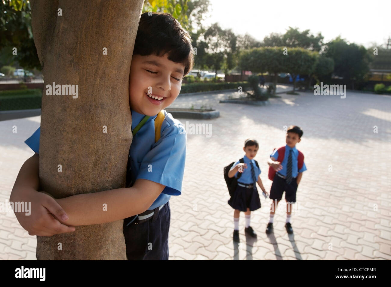 Schuljunge umarmt einen Baum Stockfoto