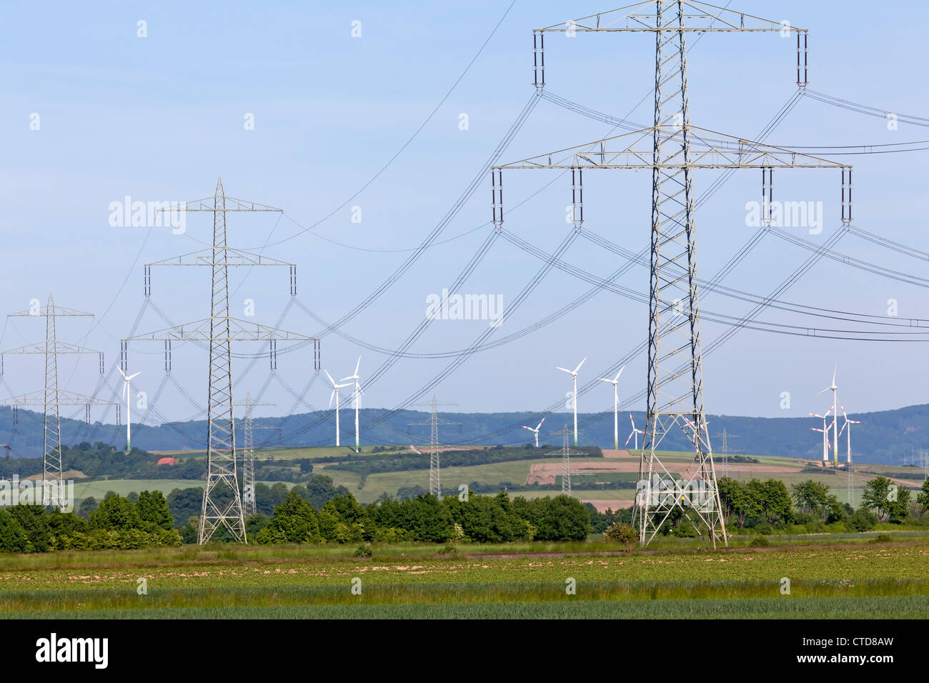 Windkraftanlagen mit Strommasten Stockfoto