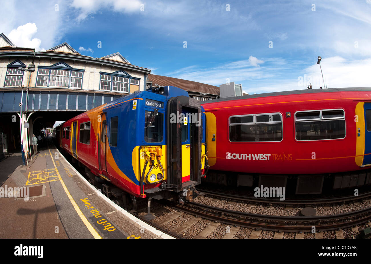 Züge in bunten South West Trains Lackierung wartet am Bahnhof Clapham Junction, London, England. Stockfoto