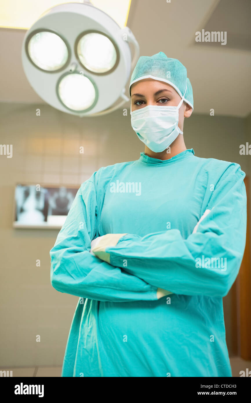 Krankenschwester mit verschränkten während des Tragens chirurgische Kleidung Stockfoto