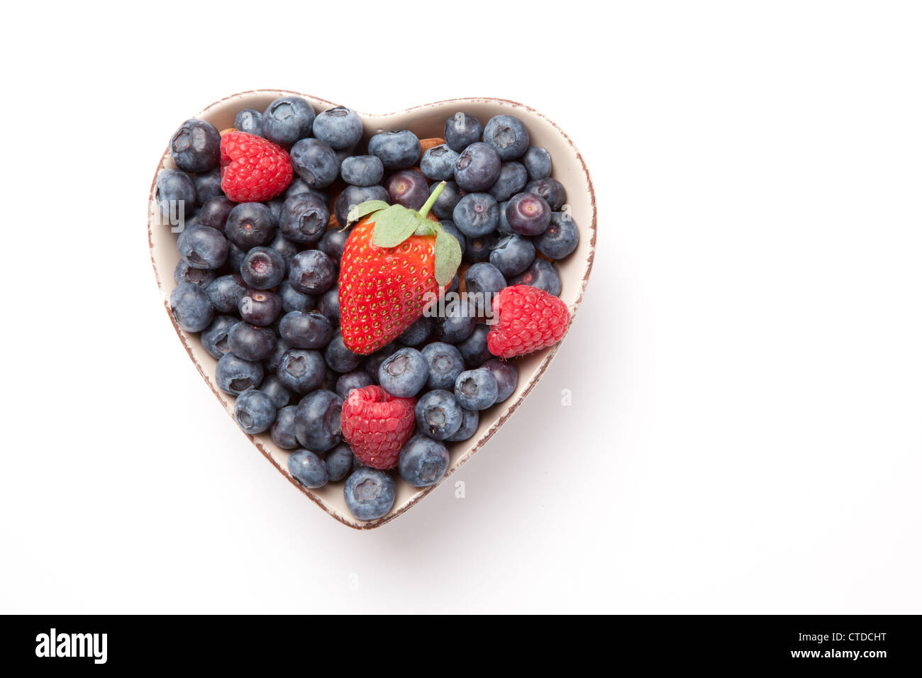 Verschiedene Beeren in eine herzförmige Schüssel Stockfoto