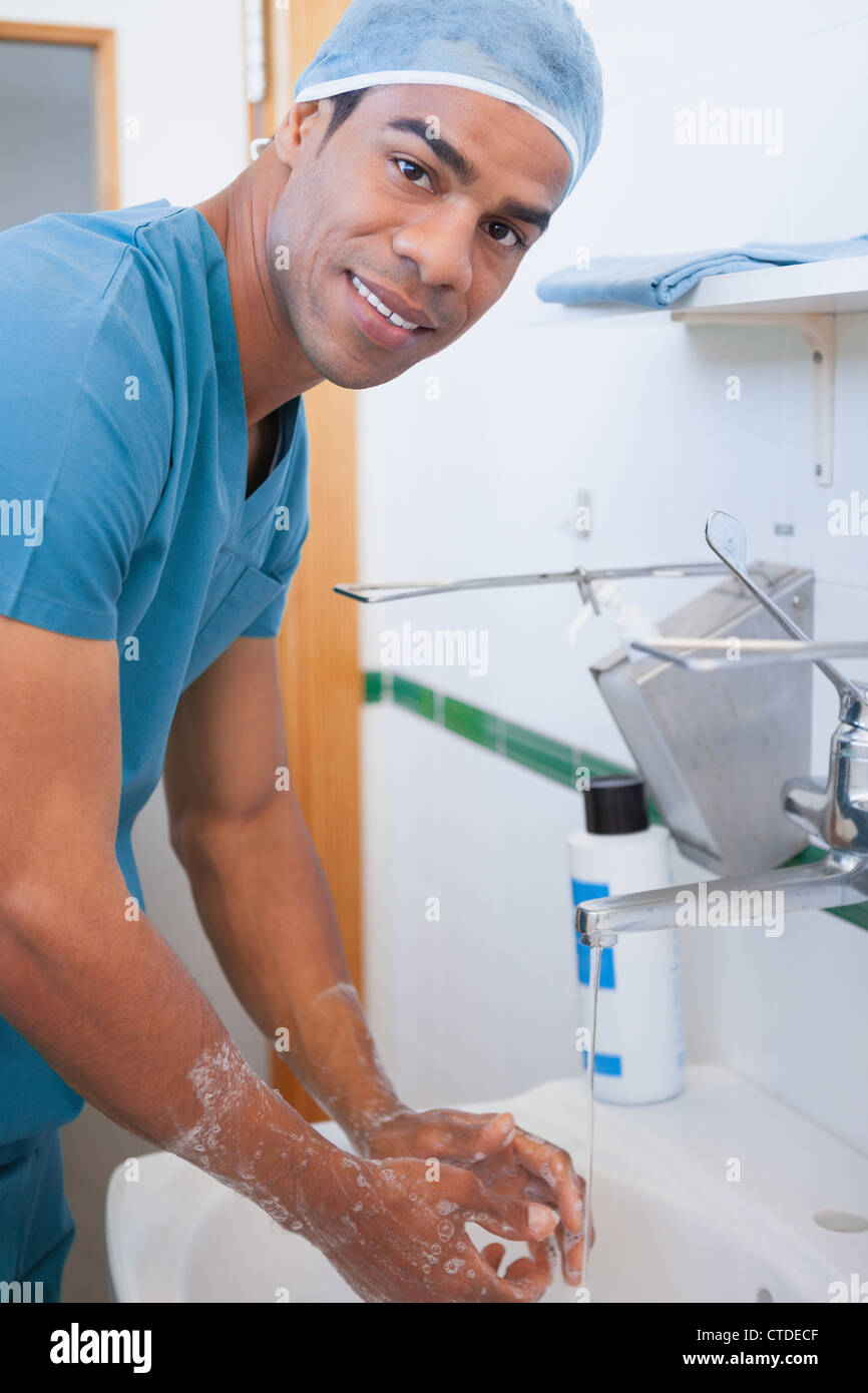 Glücklich männliche Chirurgen, die Hände mit Seife waschen Stockfoto