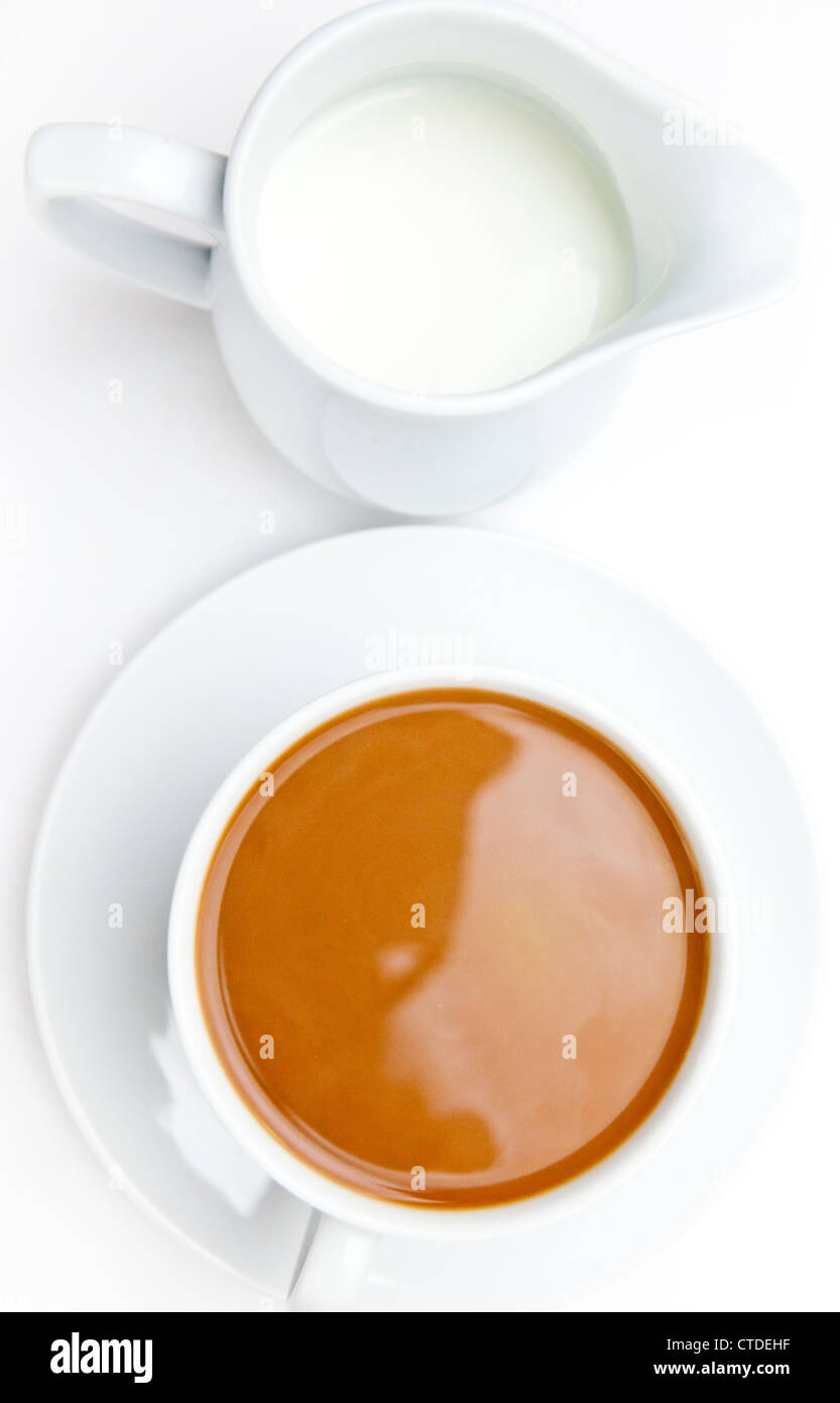 Weiße Tasse Kaffee neben einem Milchtopf Stockfoto