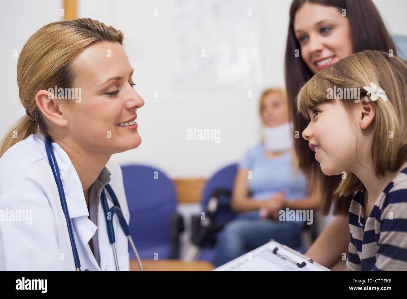Arzt für Allgemeinmedizin im Gespräch mit einem Mädchen in einem Wartezimmer Stockfoto