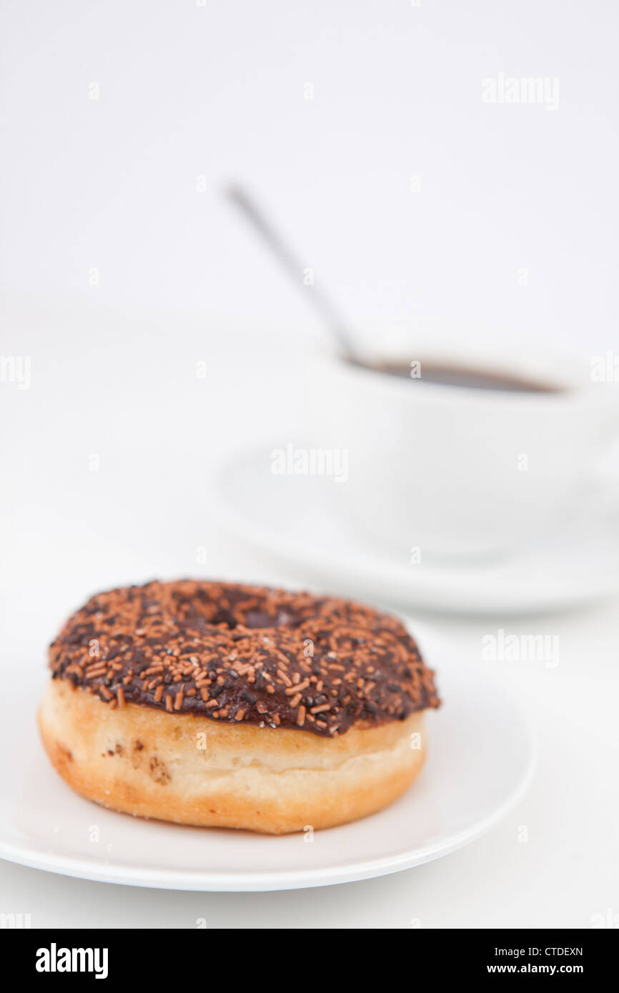 Schoko Donut und eine Tasse Kaffee auf weißen Platten Stockfoto