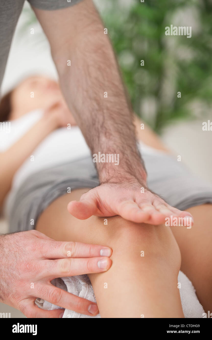 Physiotherapeut mit seine Hand mit der Handfläche zu eine Knie massage Stockfoto