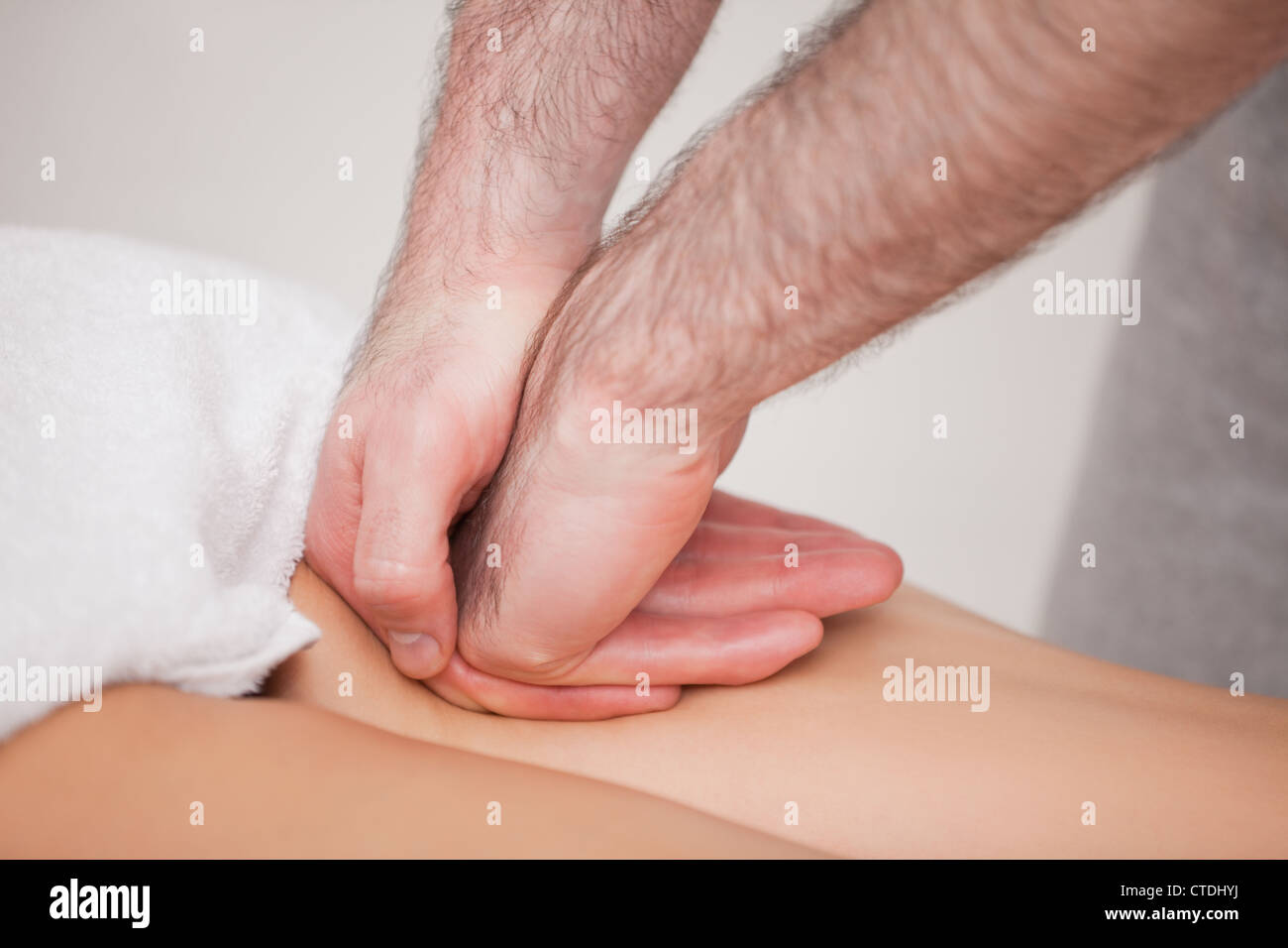 Praktiker, die Massage der Oberschenkel seines Patienten Stockfoto