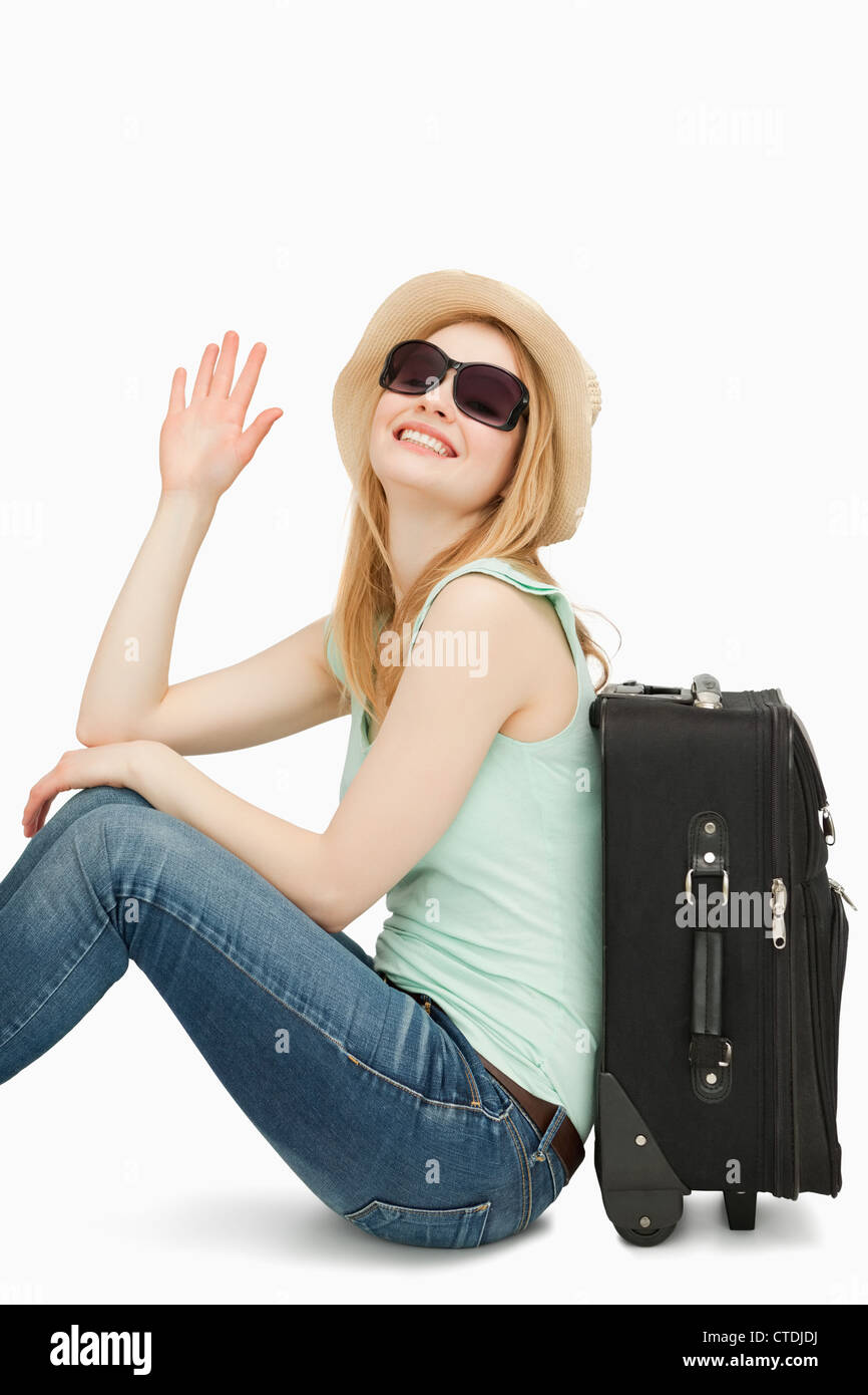 Frau Sainsing ihre Hand beim Sitzen in der Nähe von einem Koffer Stockfoto