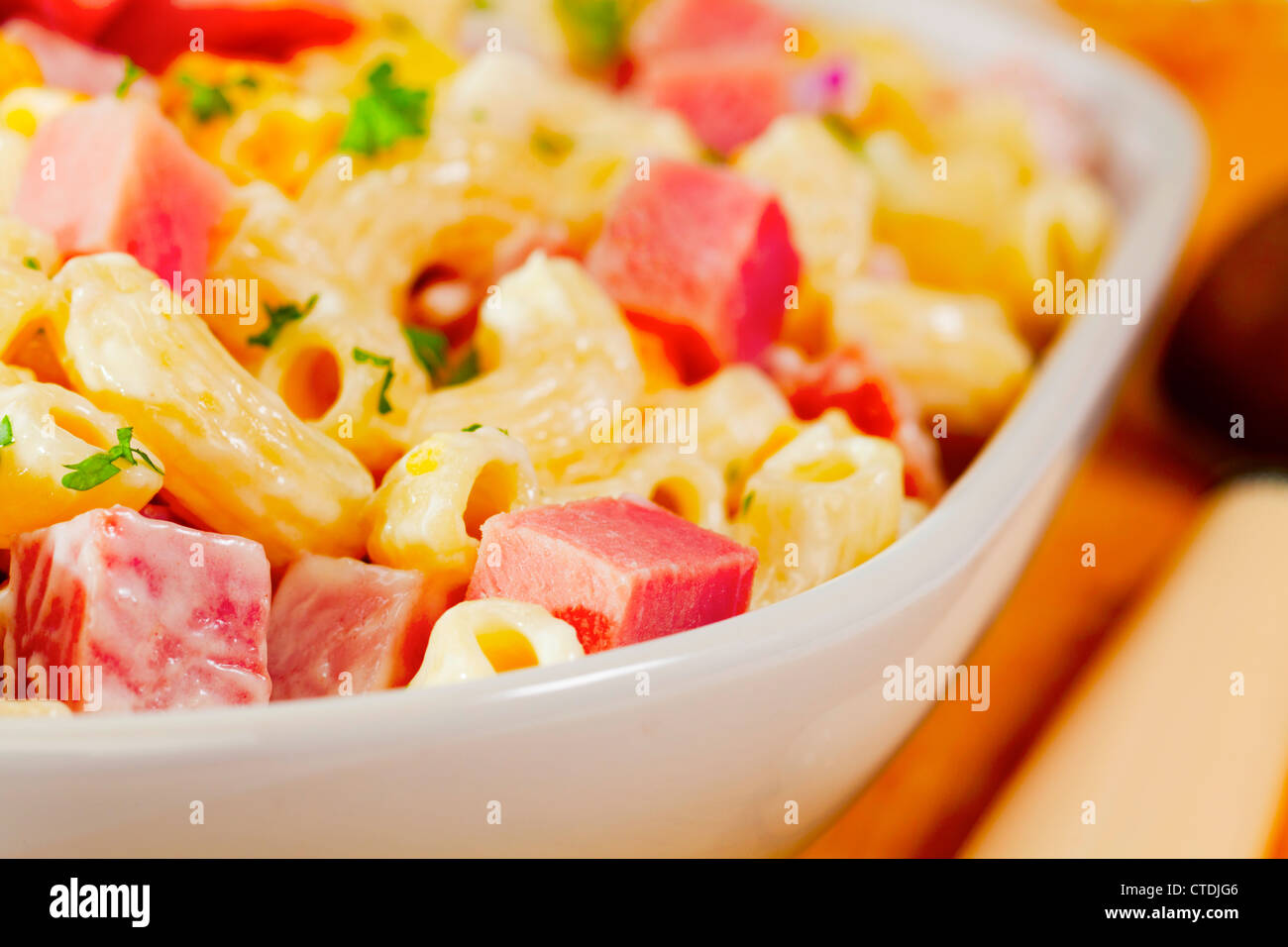 Makkaronisalat mit Schinken, Käse, Mais, roten Zwiebeln und Gurken und einem leichten Dressing aus Mayonnaise und low fat Joghurt hergestellt. Stockfoto