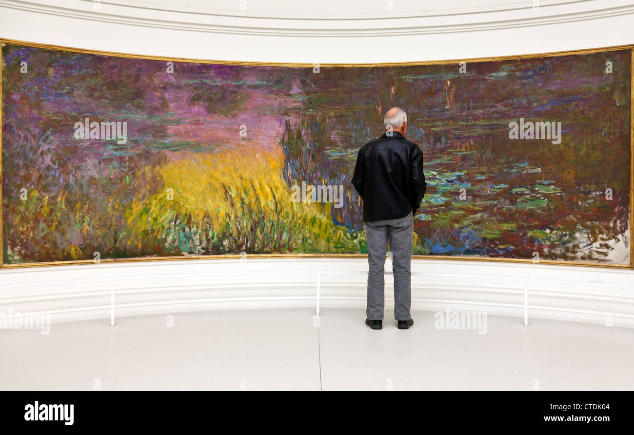 Mann, die Anzeige eines der acht "Nympheas" (Monets Seerosen Wandmalereien) in das Musee de l ' Orangerie in Paris. Stockfoto