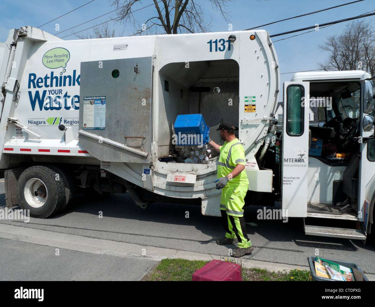 Garbage man Loading überdenken Sie die Müllverwertung von Lkw-Müllwagen mit Bordsteinsammlung von recyceltem Haushaltspapier in Fort Erie Ontario Kanada KATHY DEWITT Stockfoto