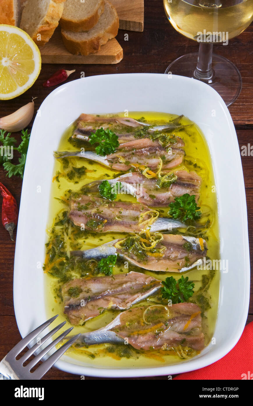 Marinierte Sardellen mit Olivenöl, Petersilie, Knoblauch, Paprika, Orangen- und Zitronenbäumen Haut Stockfoto