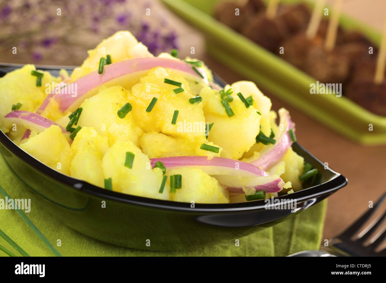 Kartoffelsalat mit Zwiebeln in Schwäbisch-Stil (Süddeutschland) mit einer Essig-Senf-Sauce, garniert mit Schnittlauch zubereitet Stockfoto