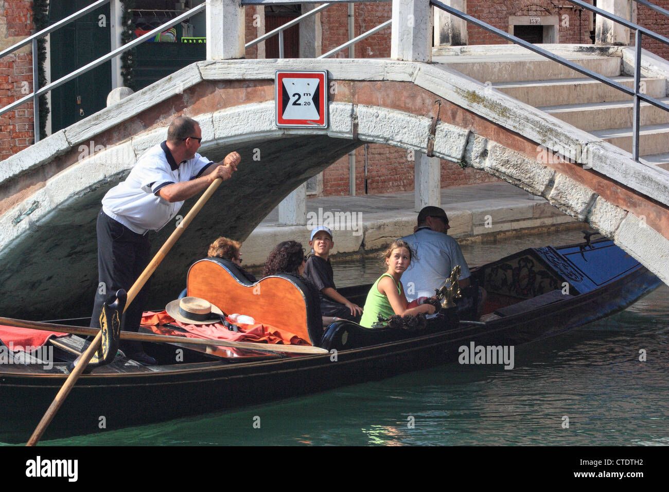 Gondelfahrt unter den niedrigen Brücken von Venedig Stockfoto
