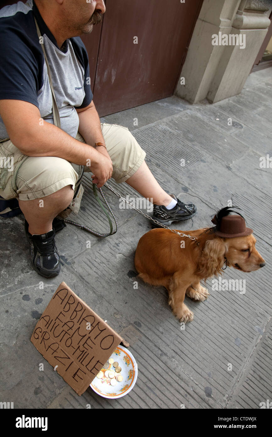 Bettler mit Hund auf Straße in Zentral-Florenz, Italien - Zeichen sagt hungrig Stockfoto