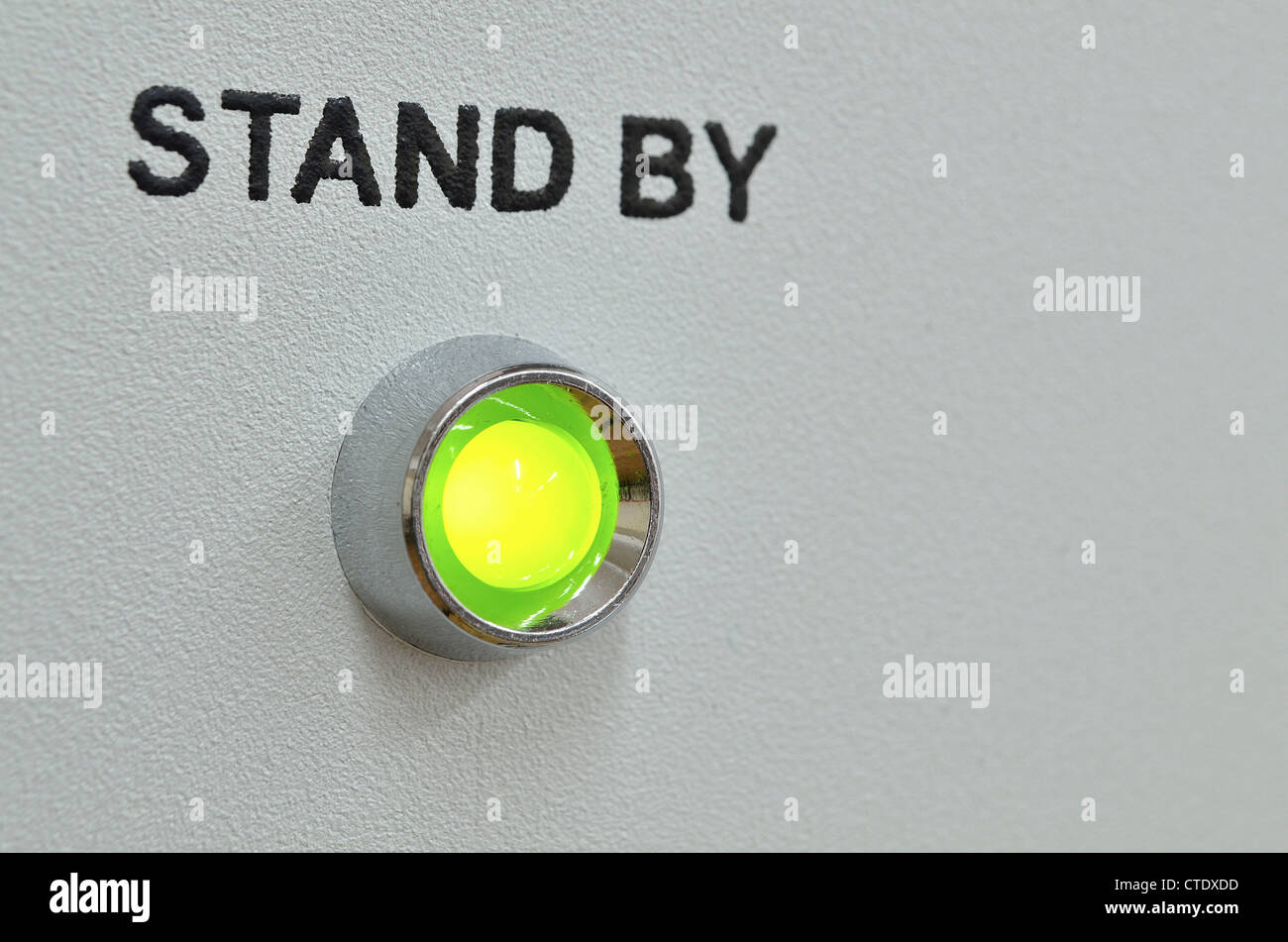 grüne LED-Beleuchtung mit Stand-by-Text über sie im grauen Bereich des Geräts; grüne LED im Fokus Stockfoto