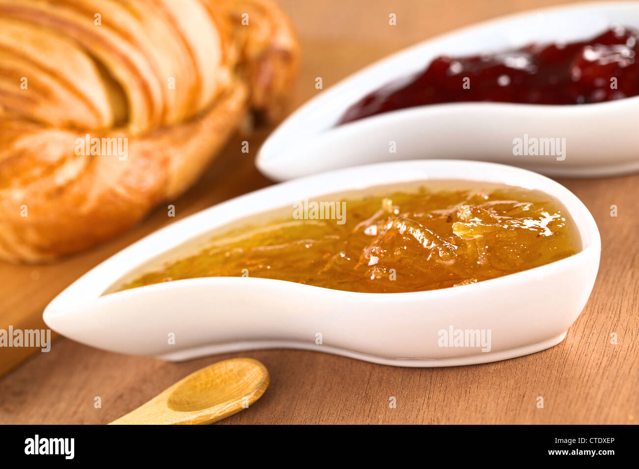 Orange und Erdbeere Marmelade mit Croissant (selektiven Fokus, Fokus auf der Vorderseite des Orangenkonfitüre auf der rechten Seite des Bildes) Stockfoto