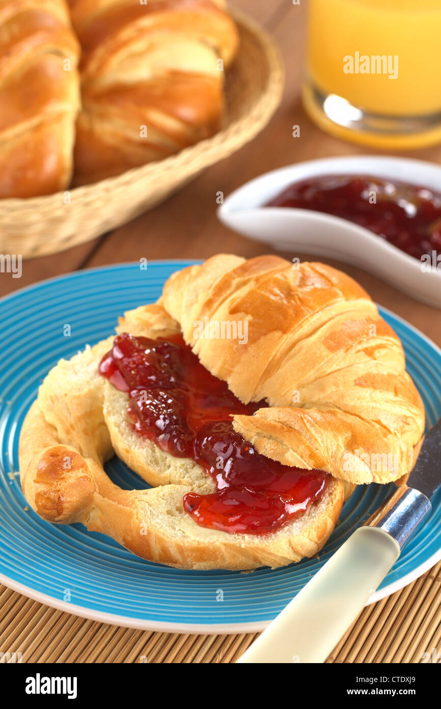 Croissant mit Butter und Strawberry Jam (selektiven Fokus, Fokus auf der Vorderseite die Erdbeermarmelade) Stockfoto