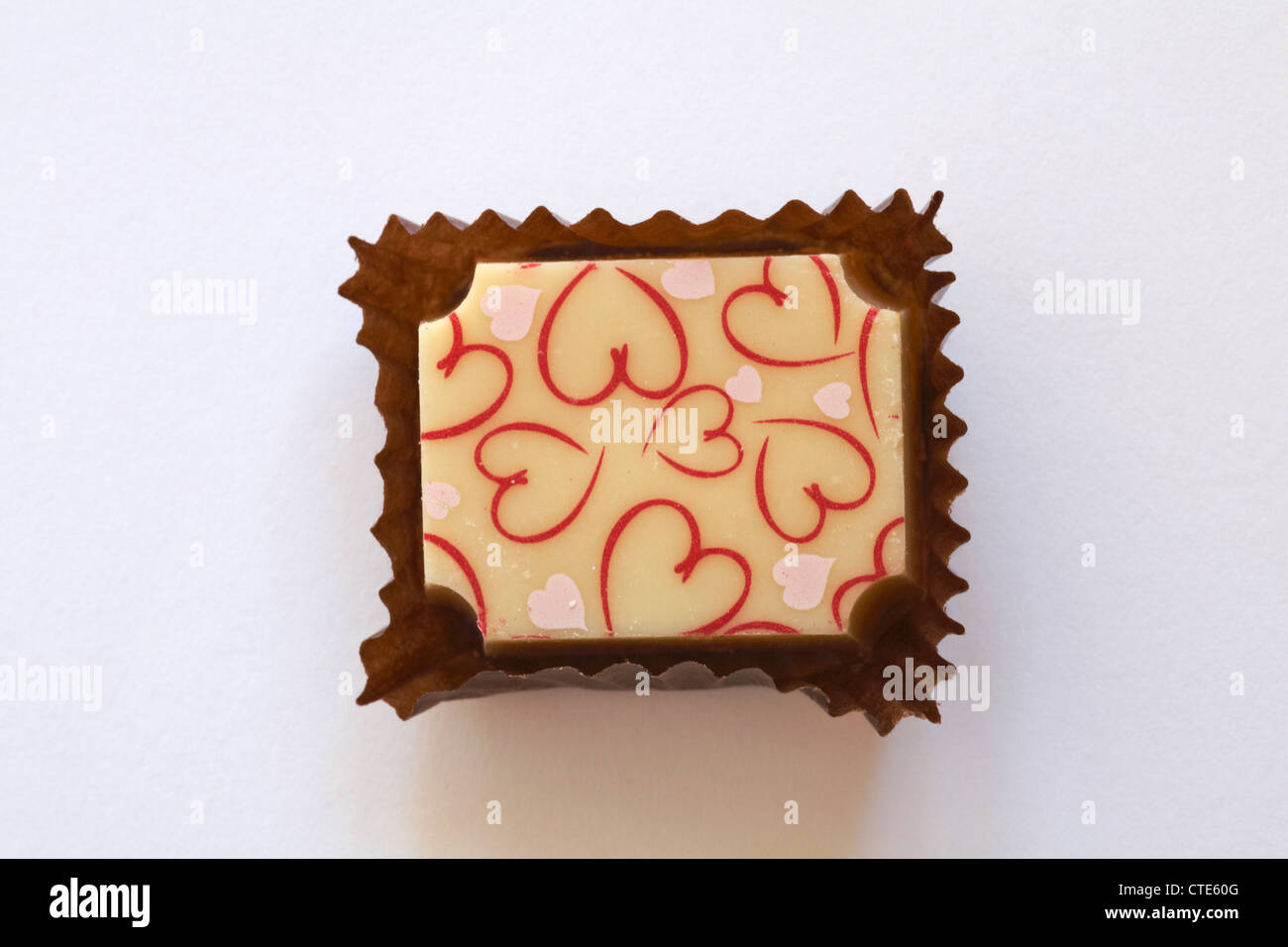 Luxus-weiße Schokolade mit Herz auf Papier bei isoliert auf weißem Hintergrund Stockfoto