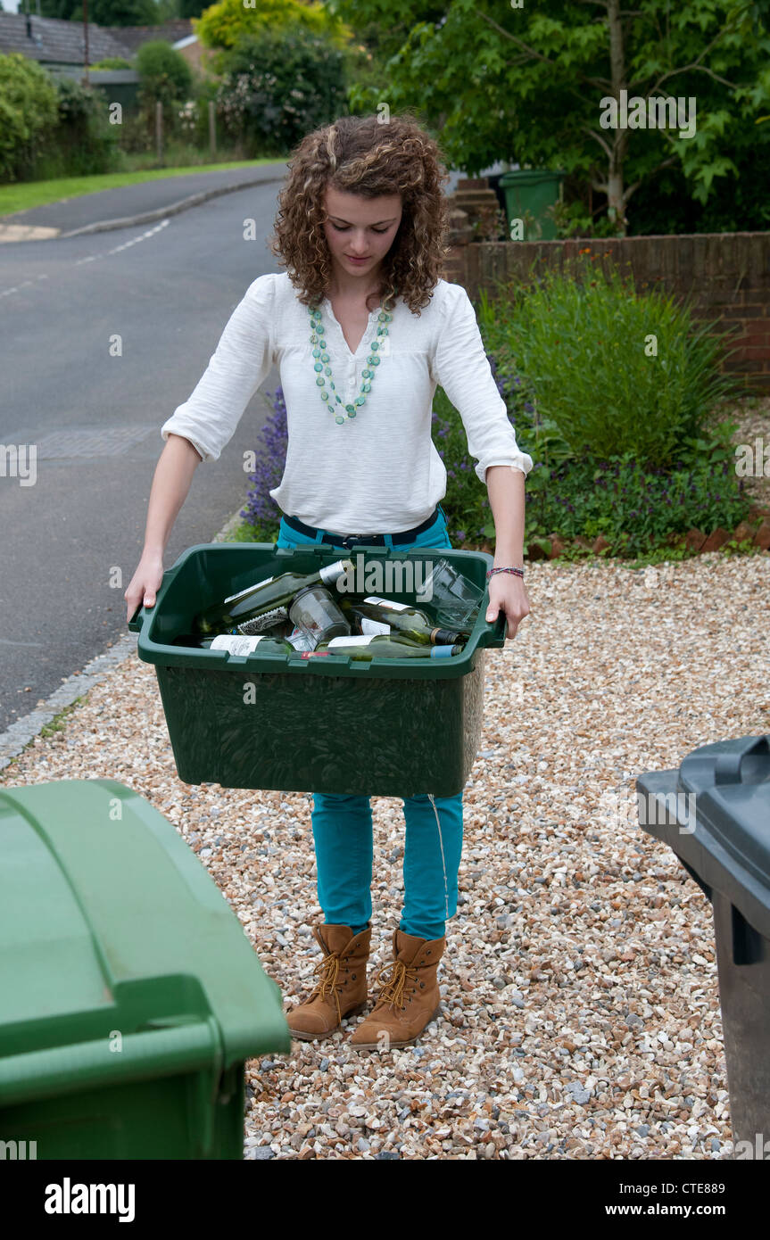 Junge Frau hält eine Schachtel mit Glasflaschen und Gläser für das recycling Stockfoto