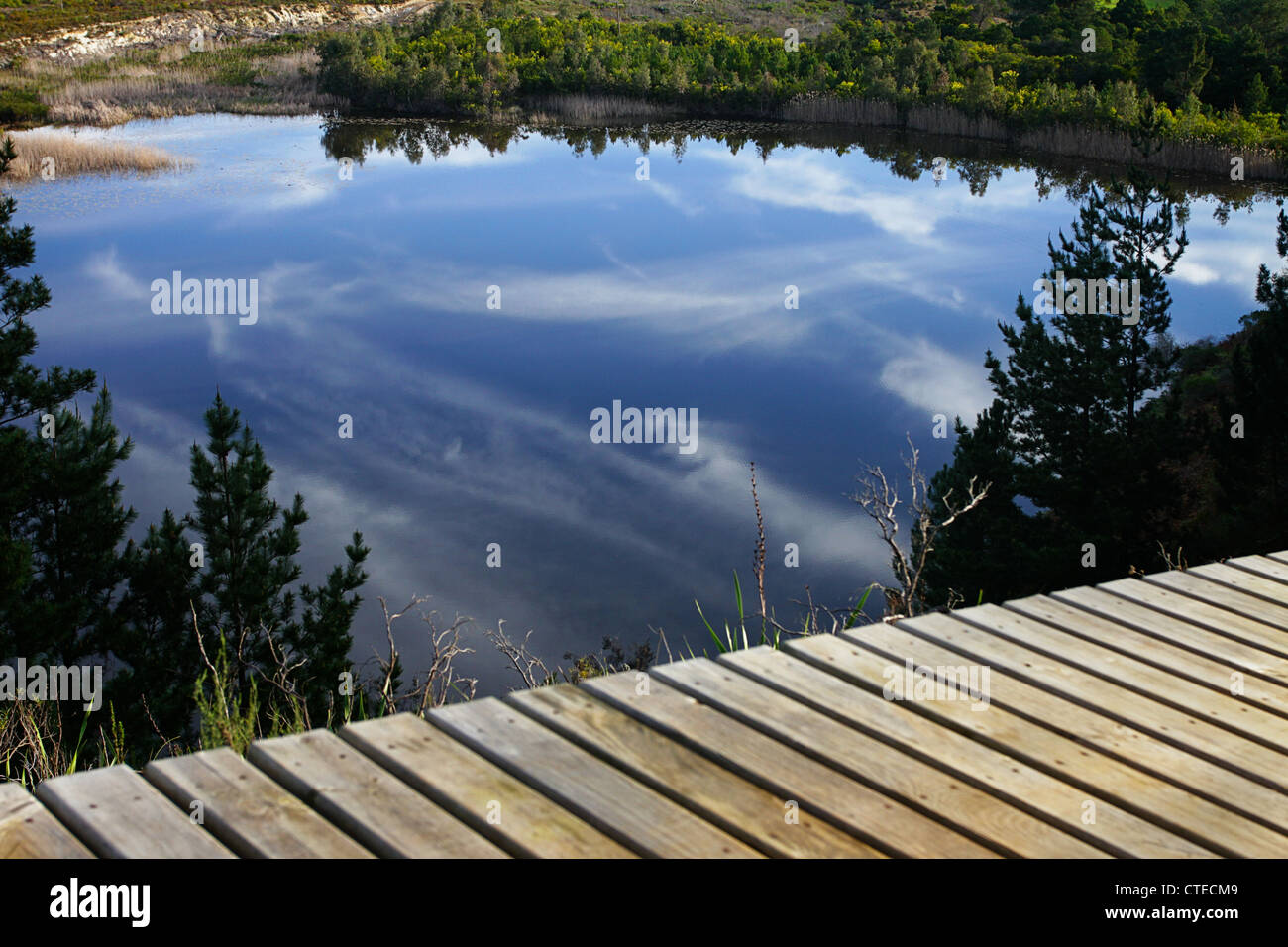 Wolken reflektiert, an einem See mit einem Holzsteg im Vordergrund Stockfoto