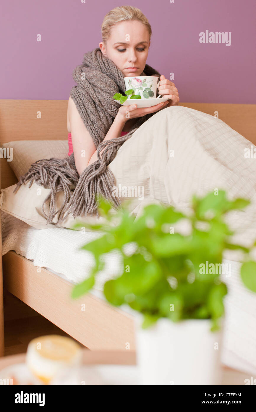 Kranke Frau trinken Kräutertee Stockfoto