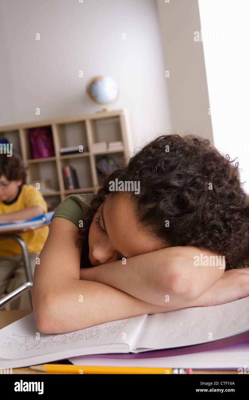 USA, California, Los Angeles, Mädchen (10-11) Nickerchen auf Schreibtisch mit jungen (10-11) im Hintergrund Stockfoto