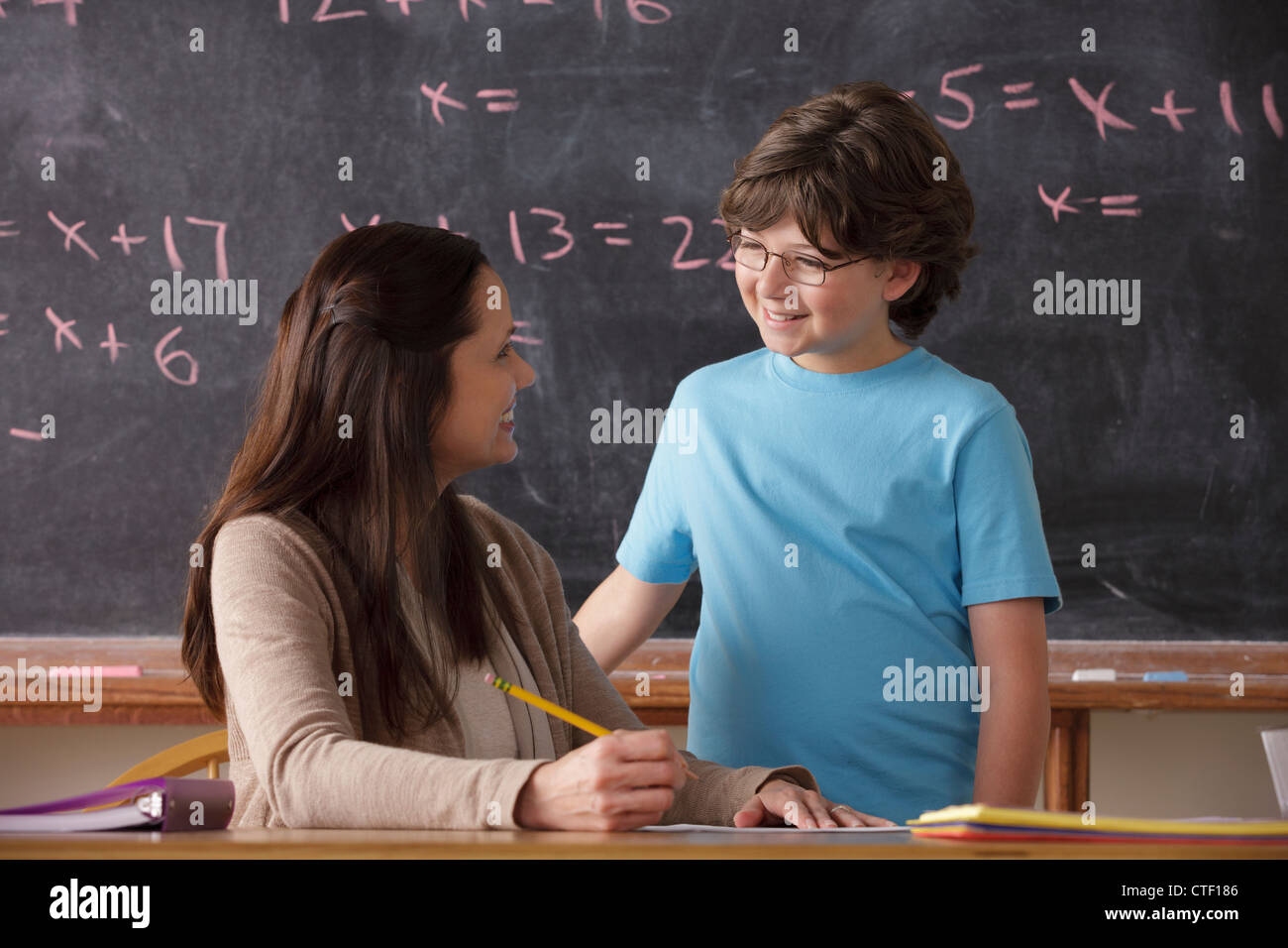 USA, California, Los Angeles, Schüler (10-11) und Lehrer Angesicht zu Angesicht mit Tafel im Hintergrund Stockfoto