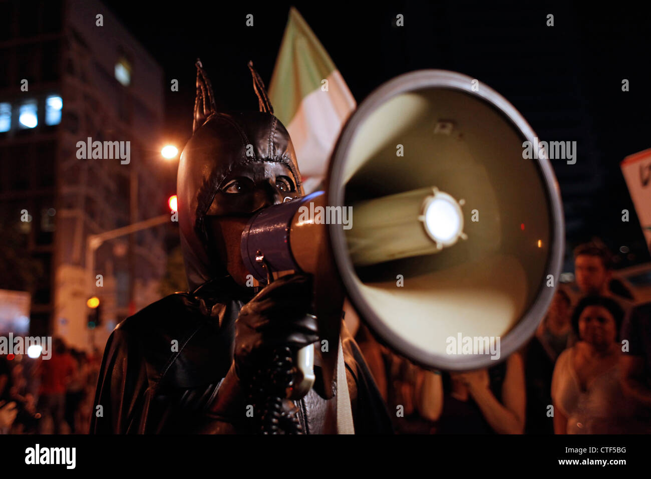 Ein israelischer Demonstranten in Batman-Kleidung, der während des Cost of Living-Protests in Tel Aviv Israel Anti-Regierungslosungen durch ein Bullhorn ruft. Der Protest gegen soziale Gerechtigkeit, der auch als Protest gegen Zelte bezeichnet wurde, war eine Reihe von Demonstrationen in Israel, die im Juli 2011 begannen und Hunderttausende von Demonstranten aus verschiedenen sozioökonomischen Bereichen gegen den anhaltenden Anstieg der Lebenshaltungskosten, insbesondere der Wohnkosten, einsetzten. Stockfoto