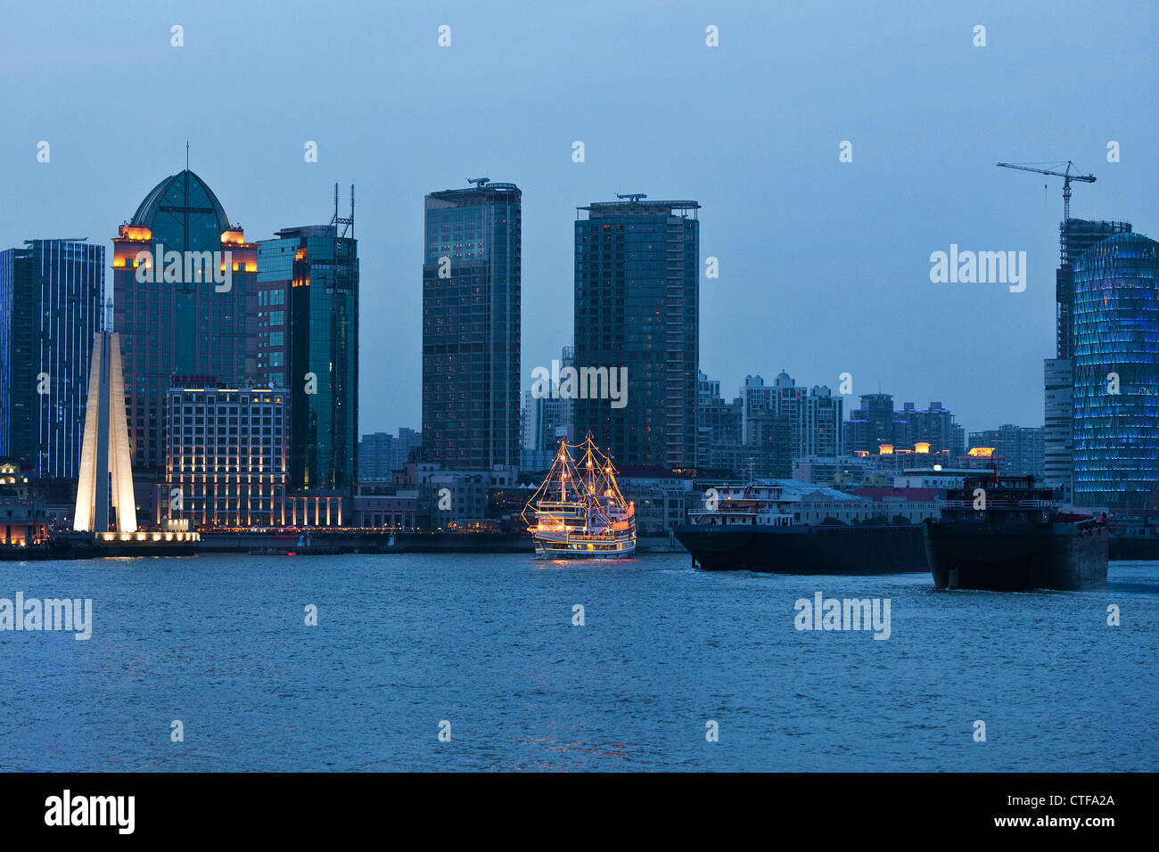 Shanghai-Wolkenkratzer in der Nähe von Wasser in der Nacht mit Spiegel Stockfoto