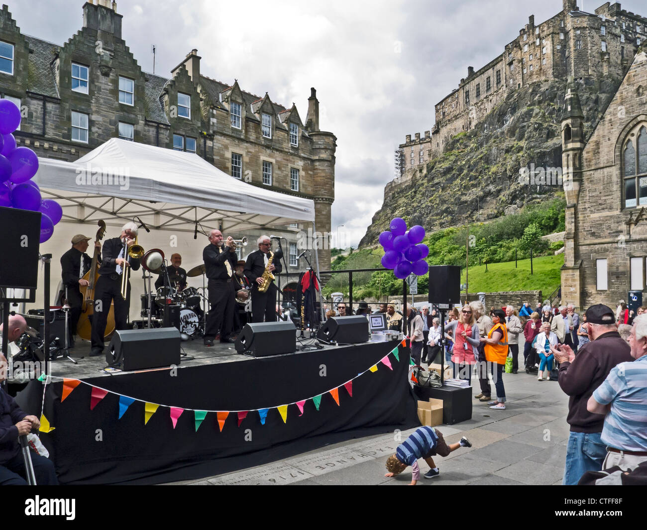Die Savannah-Jazzband spielt in der Grassmarket Edinburgh bei Eröffnung des Edinburgh Jazz und Blues Festival mit Burg hinter Stockfoto